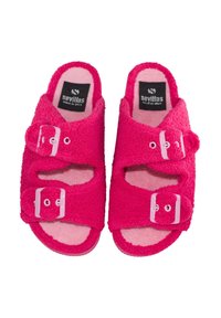 Sandalias tipo slip de rizo en rosa brillante con dos hebillas ajustables y etiquetas "Sevillas Made in Spain" en el interior.