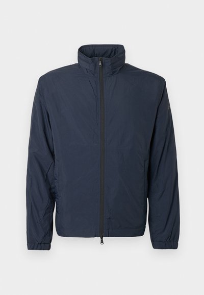 Ναυτικό μπλε ελαφρύ μπουφάν με ψηλό γιακά, πλήρη μπροστινό φερμουάρ, ελαστικούς καρπούς και μινιμαλιστικό σχέδιο; λεία υφή και χωρίς σχέδια.