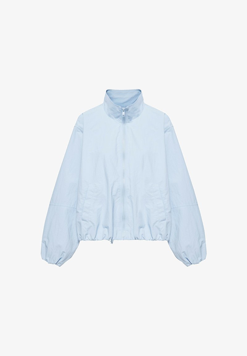 Veste bleu clair zippée avec col montant, manches longues bouffantes, poches avant et ourlet élastiqué sur fond blanc.