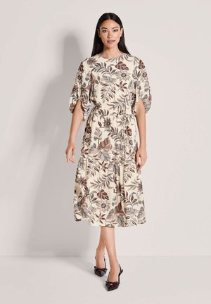 Florales Midikleid mit cremefarbenem Hintergrund, verziert mit braunen und burgunderfarbenen Blattmustern, kurzen Puffärmeln und einer taillierten Detailverzierung.