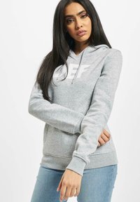 Šedá mikina s kapucňou, vyrobená z mäkkého materiálu, s prednou klokankou, šnúrkami na kapucni a veľkým bielym logom "DEF" na hrudi.