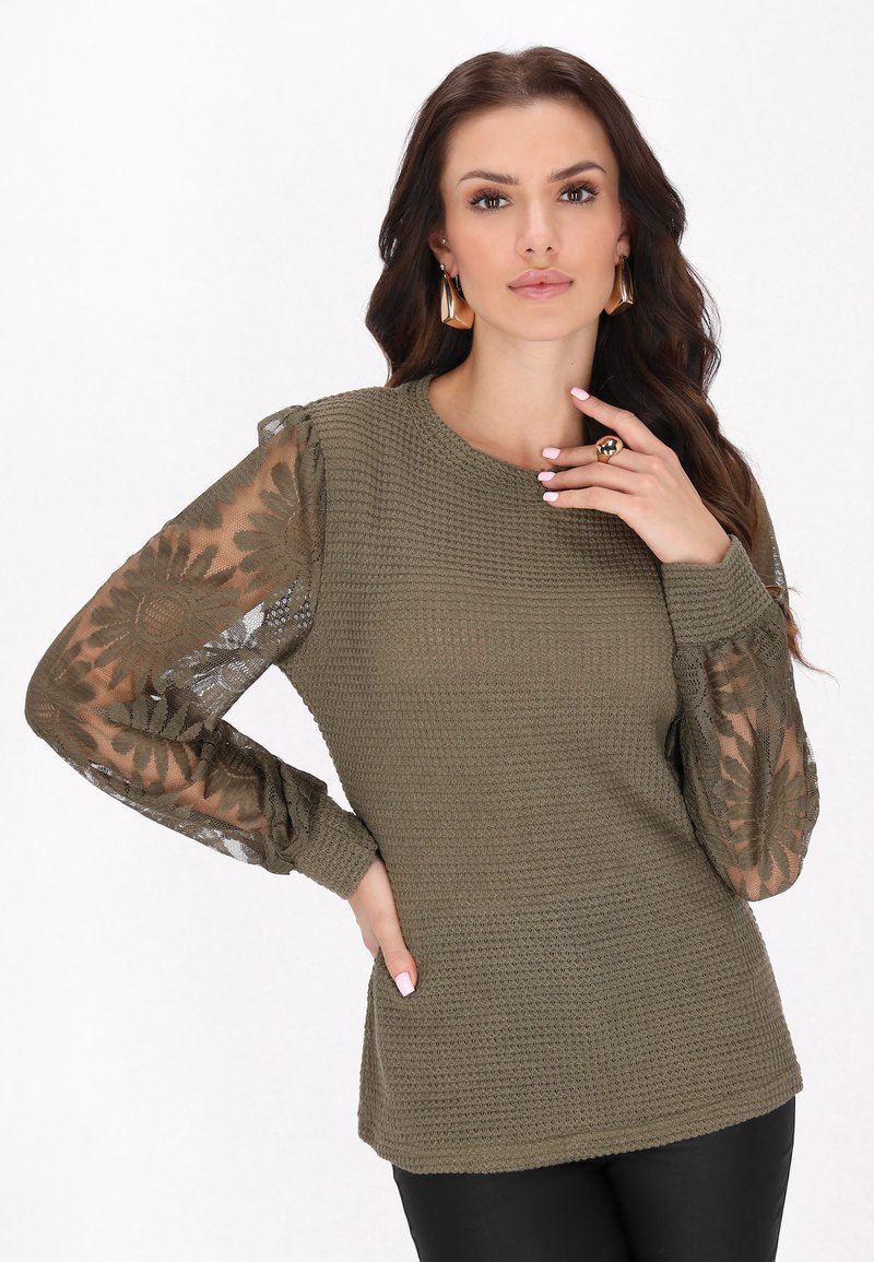 Pulover verde măsliniu cu un corp texturat, mâneci din dantelă semi-transparentă cu modele florale și manșete plisate. Finisaj neted pe corp.