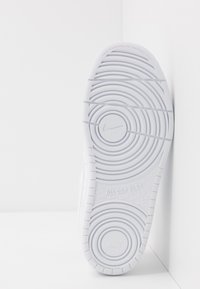 Suola di scarpa sportiva bianca con motivi a cerchi concentrici, testo "NON MARKING" e "ALL DAY PLAY", e un logo Nike in evidenza.