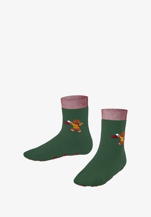 Chaussettes vertes avec des bords rayés rouges et blancs, ornées d'un bonhomme en pain d'épice tenant une chaussette rouge de chaque côté.