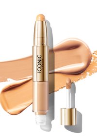 Correttore liquido in un applicatore in plastica oro e trasparente. Presenta una punta a spugna e una tonalità di crema beige con una texture liscia.