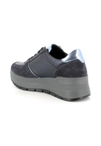 Sneaker grigio scuro con una combinazione di texture in suede e pelle, dettagli metallici sul tallone e una suola spessa e texture per aumentare l'altezza.