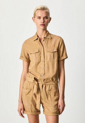 Mono corto khaki hecho de tela ligera; cuenta con mangas cortas, dos bolsillos en el pecho, una cintura ceñida y puños doblados.