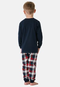 Langärmliges navyblaues Baumwolloberteil kombiniert mit gemusterten Schlafanzughosen in Rot, Grün, Weiß und navyblauem Karomuster, mit elastischen Bündchen und Knöcheln.