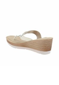 Sandale compensée en beige avec une semelle texturée ressemblant à du liège. Elle présente une fine lanière blanche avec des embellissements pour une touche décorative.