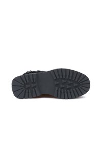 Suola di scarpa in gomma nera caratterizzata da un motivo di battistrada robusto per una maggiore aderenza. Il materiale è durevole e presenta una superficie testurizzata.