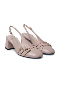 Scarpe slingback in pelle verniciata beige con tacco a blocco, tre cinture decorative con fibbie e un design a punta arrotondata.
