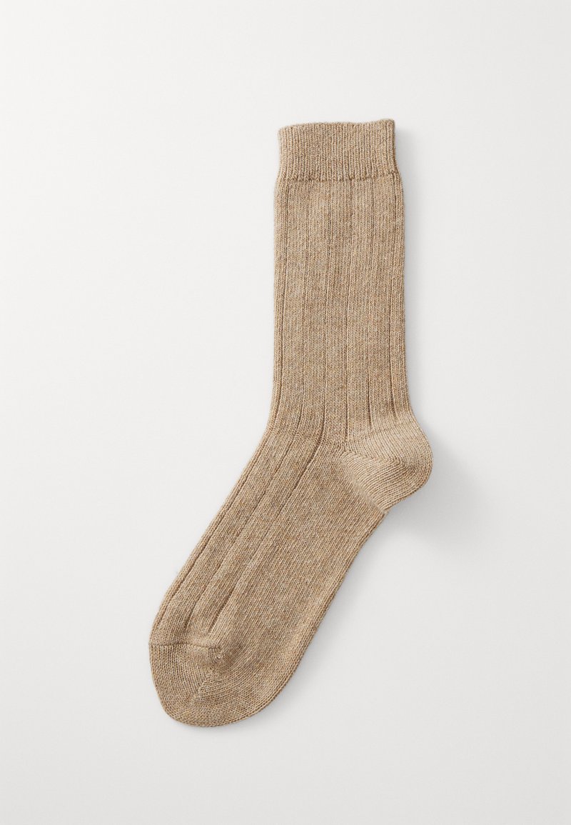Beige gerippte Socke mit verstärkter Ferse und Spitze, ausgestattet mit einem strukturierten Strickmuster und einem klassischen Bunddesign.