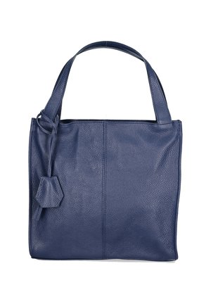 Sac fourre-tout en cuir bleu marine avec une surface texturée, une poignée unique et un petit accent hexagonal attaché sur le côté.
