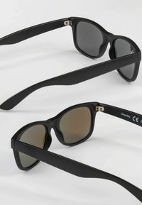 Black sunglasses with matte finish, square frame, and gradient lenses. Features metal hinges and branding on the temple. Soft texture.