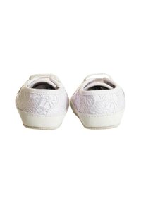Scarpe bianche con una parte superiore in pizzo tessurizzato e suola bianca liscia. Tacco corto con una forma arrotondata e una cinghia sul retro per facilitare l'indossamento.
