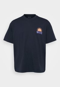 Juoda medvilninė marškinėlių su grafika, kurioje pavaizduotas saulė ir tekstas "SOLAR" oranžine ir purpurine spalvomis. Trumpomis rankovėmis, apvaliu iškirpimu, laisvas kirpimas.