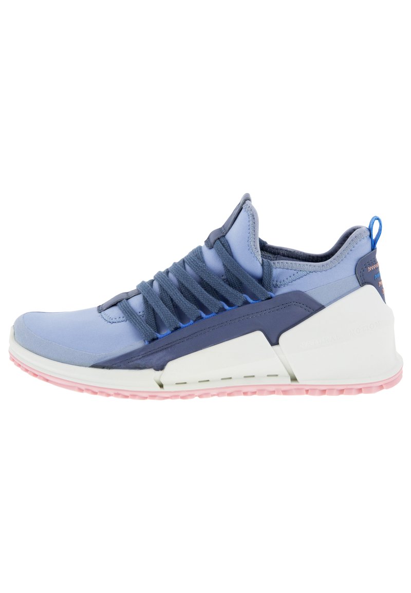 Zapatilla deportiva en azul y marino, con una parte superior de malla elástica, suela de goma, cordones elásticos y una media suela blanca con acentos rosas.