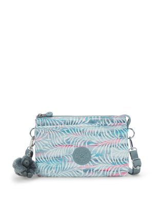 Textile crossbody bag in light blue with tropical leaf pattern, zip closure, rubber logo patch, and grey plush monkey keychain detail.