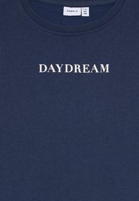 Mørkeblå hettegenser med hvit "DAYDREAM"-tekst og størrelsesetikett "name it 7-8y 122-128" på kragen.