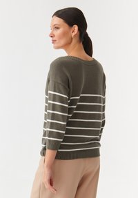 Olivgrüner Strickpullover mit weißen horizontalen Streifen, weitem Ausschnitt und dreiviertellangen Ärmeln, mit geripptem Saum und Bündchen.