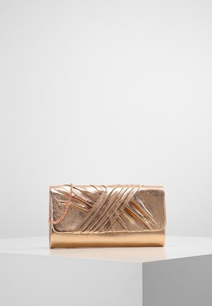Metaliczna kopertówka w kolorze różowego złota z fakturowanym, ukośnym wzorem pasków i delikatnym łańcuszkowym paskiem na białym piedestale.