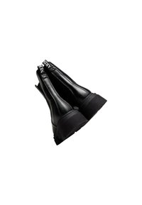 Zwarte enkellaarsjes met een dikke plateauzool, een gladleren bovenwerk en elastische zijpanelen met contrasterende logodetails.