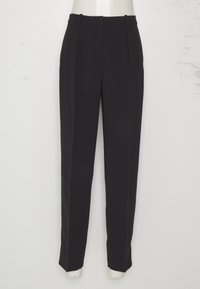 Mustat räätälöidyt housut, jotka on valmistettu sileästä kankaasta. Niissä on korkea vyötärö, vyönlenkit ja terävät urat edessä muodollista ilmettä varten.