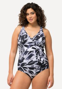 Svart och vit blommönstrad baddräkt med omslagdesign, V-ringning och justerbart sidoband. Tillverkad av stretchigt, smidigt material.