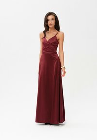Burgundská saténová maxi šaty s tenkými ramínky, drapovaným živůtkem a hladkou texturou, nabízející rozšířený siluetu a dlouhý střih až k podlaze.