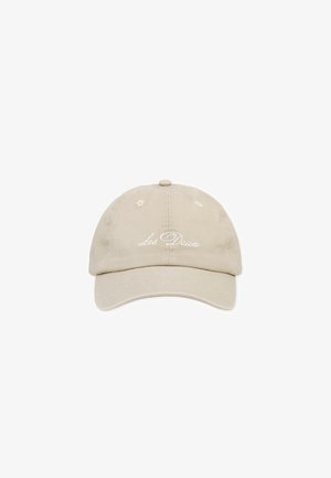 Beige cotton cap with a curved brim, featuring embroidered "Les Deux" text on the front and ventilation holes on the top.