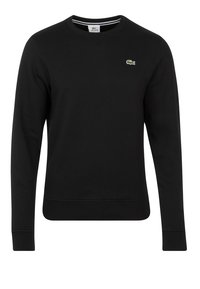 Sudadera negra de algodón, con cuello redondo, mangas largas, puños acanalados y un pequeño logo verde en el pecho. Textura suave.