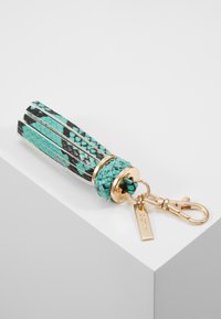 Porte-clés à pompon en cuir imprimé serpent bleu et noir avec anneaux métalliques dorés, mousqueton et une petite étiquette estampillée du nom de la marque ALDO.