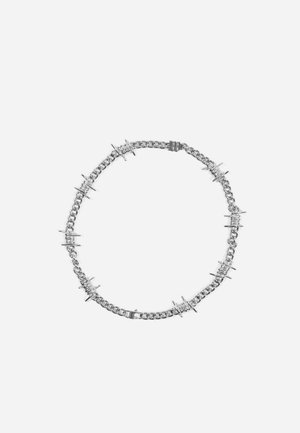 Silberne Halskette mit gleichmäßig verteilten, von Stacheldraht inspirierten Details, die einen vollständigen Kreis auf weißem Hintergrund bilden.