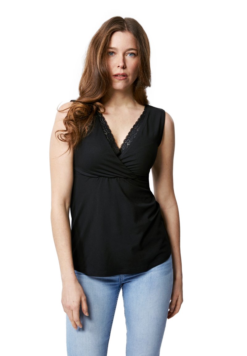 Schwarz ärmelloses Oberteil mit V-Ausschnitt und Spitzenakzenten, mit einem gerafften Frontdesign. Kombiniert mit hellblauen Jeans.