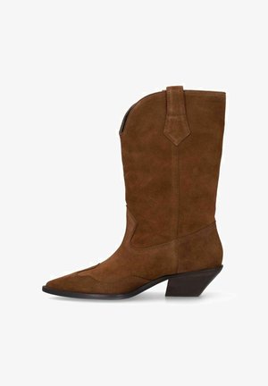 Botte de cowboy en daim marron avec bout pointu, hauteur mi-mollet, talon empilé incliné, et languette de traction sur le côté supérieur.