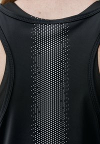 Top sportivo nero con un motivo di gradiente verticale composto da piccoli punti bianchi, tessuto liscio e scollatura rotonda con ampi fori per le braccia.