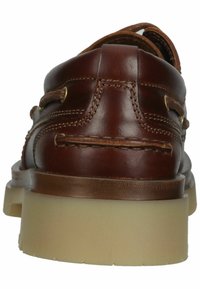 Braune Lederbootsschuhe mit runder Zehe, genähten Details, goldfarbenen Ösen und einer hellen Gummisohle.