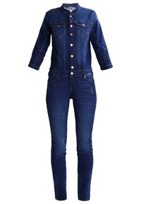 Combinaison en denim bleu foncé avec manches longues, fermeture boutonnée devant, poches poitrine et jambes ajustées.