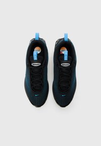 Crne i plave Nike Air Max tenisice s teksturiranim mrežastim gornjim dijelom, okruglim vrhom, crnim vezicama i plavim akcentskim detaljima na peti i jeziku.