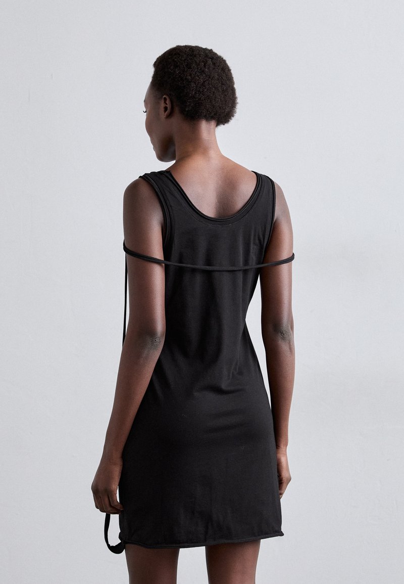 Schwarzes ärmelloses Kleid mit lockerer Passform, aus weichem Stoff, mit einem runden Rückenausschnitt und einem dünnen Träger um die Schultern.