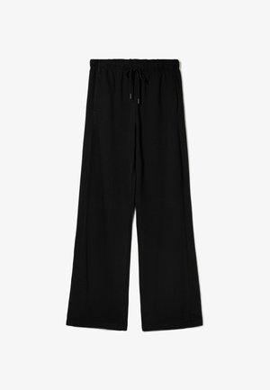 Zwarte wijde broek met elastische tailleband en verstelbare koord, plat uitgestald op een witte achtergrond.