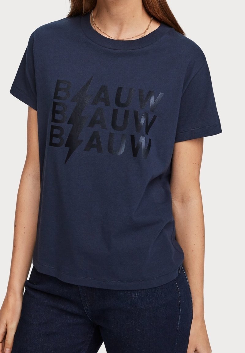 Camiseta de algodón azul marino con un estampado gráfico negro que presenta la palabra "BLAUW" en tamaños y estilos variados, acentuada por diseños de rayos.