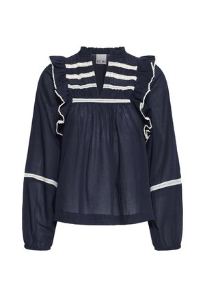 Blouse bleu marine à manches longues avec des bandes en dentelle blanche, des épaules volantées et un tissu froncé sous un décolleté plongeant en V.