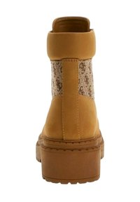 Stivaletto marrone con suola spessa, collare imbottito e pannello in tessuto a stampa serpente sul retro, visto da dietro.