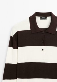 Striped polo shirt in dark brown and off-white, featuring a collar and three-button placket. Made from knit cotton material.
