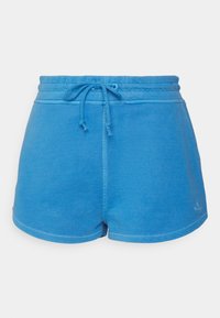 Shorts de sport bleus en tissu doux, dotés d'une ceinture élastique avec cordon de serrage et d'un détail de logo discret sur l'ourlet.