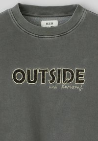 Sweatshirt gris avec un col côtelé, arborant le mot "OUTSIDE" en imprimé léopard en gras et le texte en cursive "new horizons" en dessous.