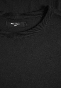 Svart stickad tröja med rundad halsringning, med en mjuk textur. Etiketten visar "Matinique" och storlek "L". En enkel, enfärgad design.