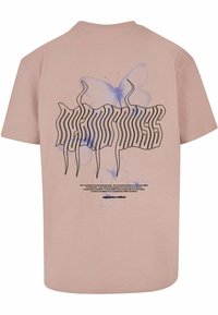 Pink cotton t-shirt featuring a large black text design with wavy lines and a translucent blue butterfly graphic on the back.