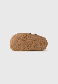 Suela de zapato de goma marrón con un patrón texturizado para agarre, que presenta áreas elevadas y un logo que dice "Froddo" en el centro.